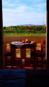 a table with a plate of fruit on it in front of a window at Kamara Apartments Marmari in Marmari