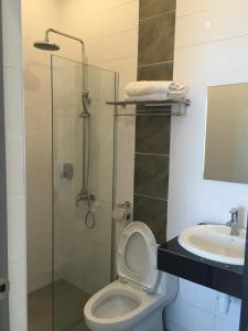 a bathroom with a shower and a toilet and a sink at Hotel Mirage PD in Port Dickson