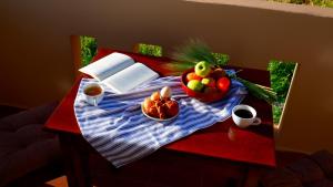 a table with a bowl of fruit and coffee on it at Kamara Apartments Marmari in Marmari