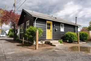 a black and yellow house with a yellow door at Retro Retreat: 1br home w/ WFH desk, livingroom, and fire pit in Kingston