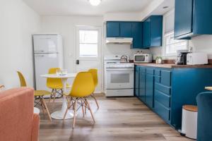 a kitchen with blue cabinets and a table and chairs at Retro Retreat: 1br home w/ WFH desk, livingroom, and fire pit in Kingston