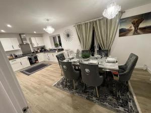 eine Küche mit einem Tisch und Stühlen sowie ein Esszimmer in der Unterkunft Luxurious 4 Bed House Manor View in Wavendon