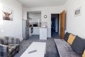 a living room with a couch and a table at Helensburgh Holiday Apartment in Helensburgh