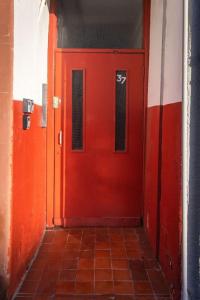 uma porta vermelha num corredor com piso em azulejo em Helensburgh Holiday Apartment em Helensburgh