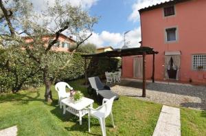 un jardín con mesa y sillas y una casa en Ferienhaus mit Privatpool für 6 Personen ca 120 qm in Carignano di Lucca, Toskana Provinz Lucca, en Cappella