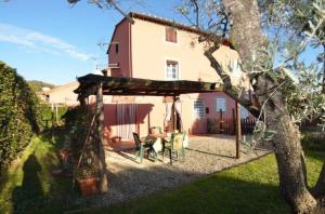 una casa con una pérgola delante de ella en Ferienhaus mit Privatpool für 6 Personen ca 120 qm in Carignano di Lucca, Toskana Provinz Lucca, en Cappella