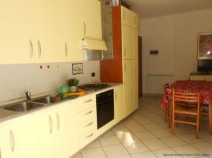 a kitchen with a sink and a stove top oven at Ferienwohnung für 4 Personen 2 Kinder ca 60 qm in Rosolina Mare, Adriaküste Italien Venedig und Umgebung in Rosolina