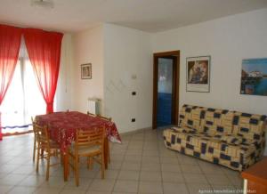 a living room with a table and a couch at Ferienwohnung für 4 Personen 2 Kinder ca 60 qm in Rosolina Mare, Adriaküste Italien Venedig und Umgebung in Rosolina