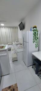 Il comprend une cuisine équipée d'appareils électroménagers blancs et d'un réfrigérateur blanc. dans l'établissement Condomínio da Fé, pertinho da Canção Nova, Flat Nossa Senhora Do Rosário, estacionamento gratuito., à Cachoeira Paulista