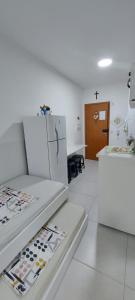 Cette chambre blanche comprend une cuisine équipée d'un réfrigérateur. dans l'établissement Condomínio da Fé, pertinho da Canção Nova, Flat Nossa Senhora Do Rosário, estacionamento gratuito., à Cachoeira Paulista