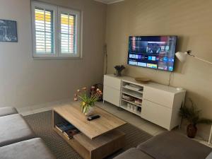 a living room with a couch and a tv at Red House Apartment With Swimming Pool in Vinišće