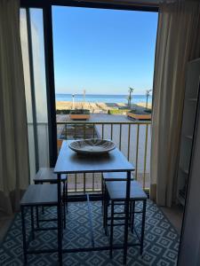 a table and chairs on a balcony with a view of the beach at Appartement vue mer in Le Barcarès