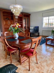 a dining room table and chairs with a vase of flowers at Villa Felicidad in Vilanova i la Geltrú