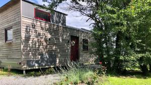 ein altes Backsteinhaus mit roter Tür in der Unterkunft Tinyhouse_Nordfriesland in Bargum