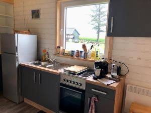 a kitchen with a stove and a sink and a window at Tinyhouse_Nordfriesland in Bargum