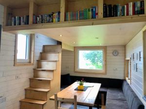 een kleine kamer met een tafel en een boekenplank bij Tinyhouse_Nordfriesland in Bargum