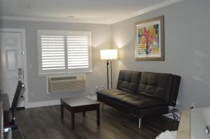 a living room with a leather couch and a window at Fairview Inn & Suites in Healdsburg