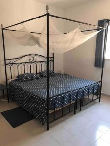 a bedroom with a black bed with a canopy at Chez Jacques Diatta in Cap Skirring