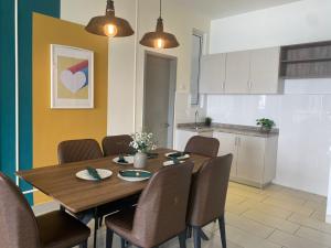 a kitchen and dining room with a wooden table and chairs at Alwafiqah Palmyra Condo 3 Bedroom- With Netflix & Wifi near Bangi, Kajang, Nilai,Putrajaya, KLIA in Kajang