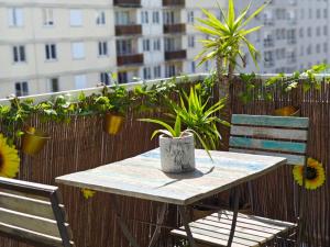 Au jardin suspendu في فانف: طاولة وكراسي على سياج به نباتات