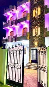 a gate in front of a building with purple lights at Sun Wing Guest House in Luxor