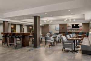 a restaurant with tables and chairs and a bar at Four Points by Sheraton Chicago Westchester/Oak Brook in Westchester