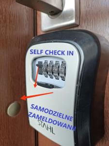 un panneau d'auto-enregistrement attaché à une porte dans l'établissement WRN APARTAMENTY, à Kalisz