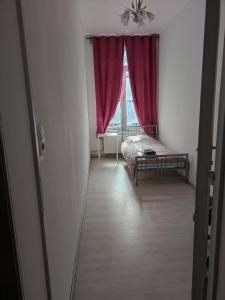 Schlafzimmer mit einem Bett und einem Fenster mit roten Vorhängen in der Unterkunft Room in Guest room - Chambre A Bruxelles a in Brüssel