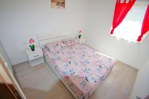 uma pequena cama num quarto com cortinas vermelhas em Ferienwohnung für 3 Personen 2 Kinder ca 55 qm in Loborika, Istrien Südküste von Istrien em Loborika