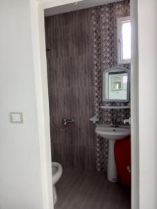 La salle de bains est pourvue d'un lavabo et d'une télévision murale. dans l'établissement Dar allouch, à Hennchir Ksar Rhaleb