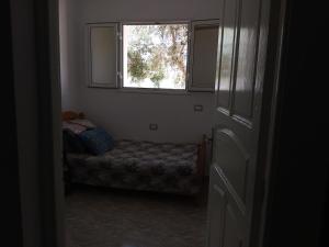 Cette petite chambre comprend un lit et une fenêtre. dans l'établissement Dar allouch, à Hennchir Ksar Rhaleb