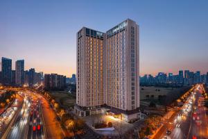 um edifício alto no meio de uma cidade com trânsito em Fairfield by Marriott Chengdu Hi-Tech Zone em Chengdu