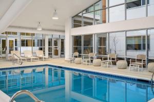a swimming pool with chairs and tables next to a building at Element Springfield South in Springfield