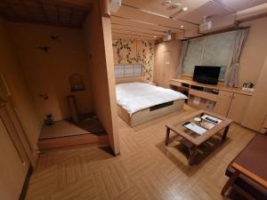 a small bedroom with a bed and a table at TsukinoAkari月燈 姫路城隣 in Himeji