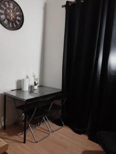 a black table with a black curtain and a clock at Sweet Belgica in Brussels