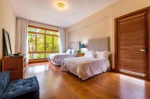 sypialnia z 2 łóżkami i dużym oknem w obiekcie Marina Pointe Apartments w mieście La Romana