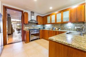 a kitchen with wooden cabinets and granite counter tops at Marina Pointe Apartments in La Romana