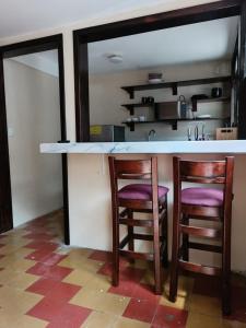a kitchen with two chairs and a counter with a counter top at El Rinconcito de la Antigua in Antigua Guatemala