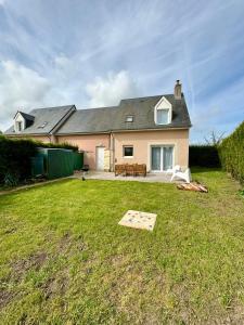 a house with a yard with a table at Charmante maison familiale in Ouistreham