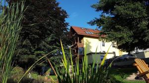 ein gelbes Haus mit rotem Dach im Hof in der Unterkunft Ferienwohnung für 6 Personen ca 100 m in Friedrichroda-Finsterbergen, Thüringen Rennsteig in Friedrichroda