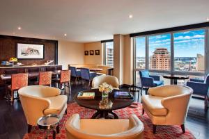 Sheraton LaGuardia East Hotel في كوينز: لوبي الفندق مع طاولة وكراسي وبار
