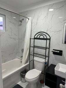 a bathroom with a toilet and a tub and a sink at Stay BnB in Nassau