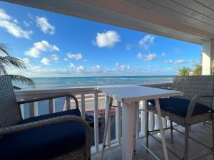a table and chairs on a balcony overlooking the beach at Stay BnB in Nassau