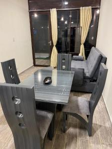 een glazen tafel en stoelen in een woonkamer met een bank bij CABAÑAS CRISTALES DE BELLA VISTA in Paipa