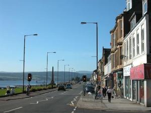 a city street with people walking down a street at Garden Cottage Helensburgh in Helensburgh