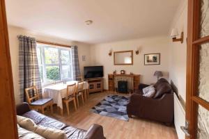 a living room with a couch and a table at Garden Cottage Helensburgh in Helensburgh