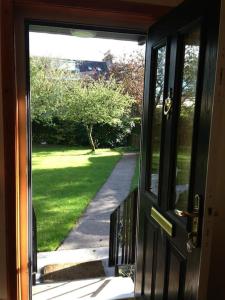 an open door with a view of a yard at Garden Cottage Helensburgh in Helensburgh +8 photos