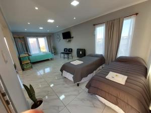 a hotel room with two beds and a television at La casita de Fran in Comandante Luis Piedra Buena