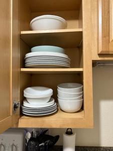 um armário cheio de pratos e tigelas numa cozinha em Nani Kai Hale em Kihei