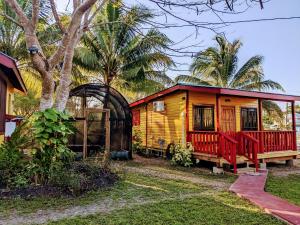 ein kleines gelbes Haus mit einer roten Veranda in der Unterkunft Garden Cottage in San Ignacio